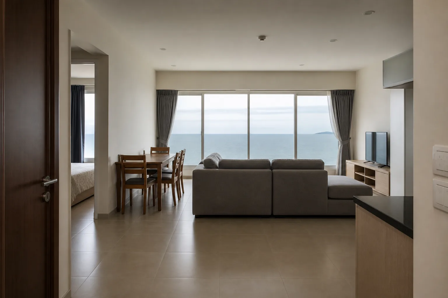 A high-floor two-bedroom rental with a full sea view from a wide living-room window